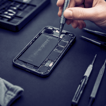 Techniker öffnet ein Smartphone mit einem Schraubendreher